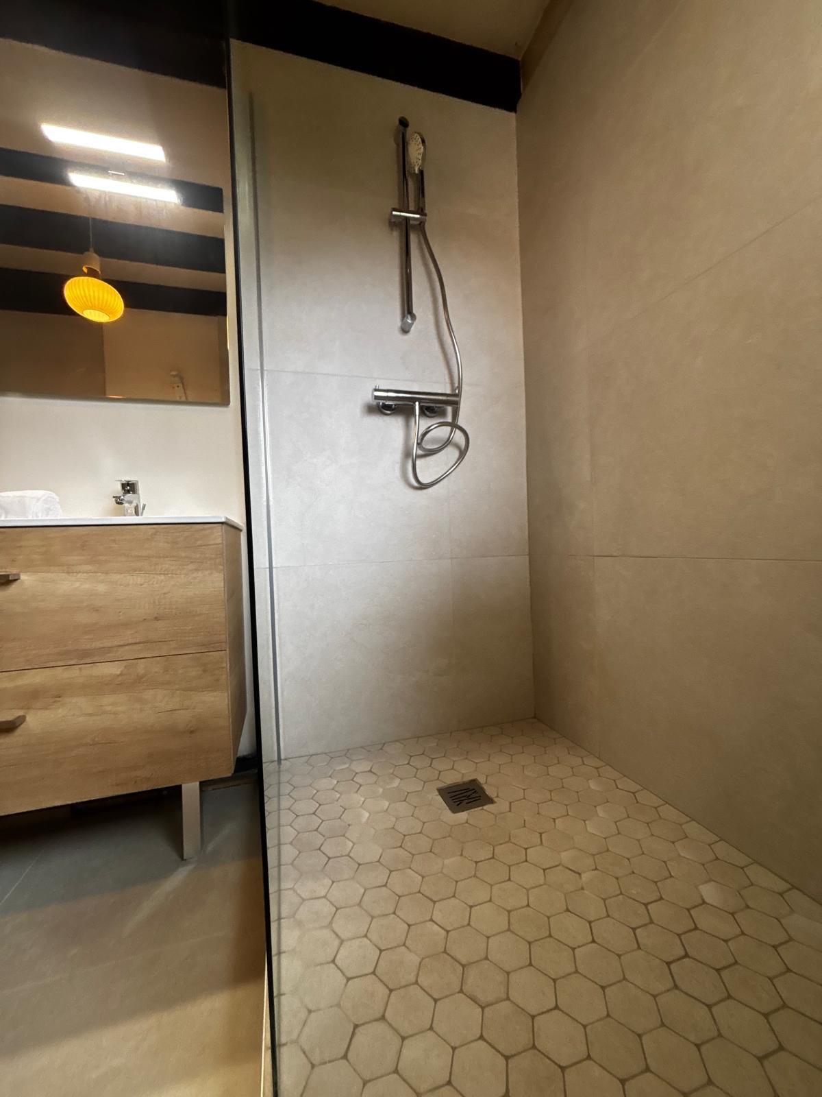 Douche à l'italienne de plain-pied avec carrelage hexagonal